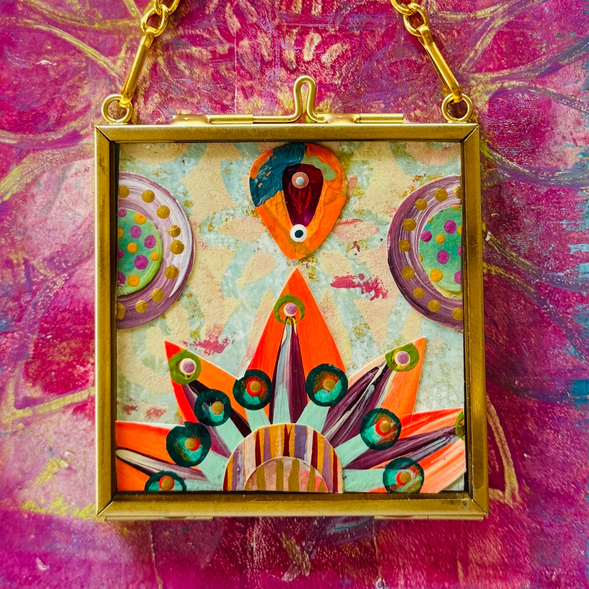 2.5" x 2.5" mixed-media collage is framed between glass in a petite brass hanging frame.
