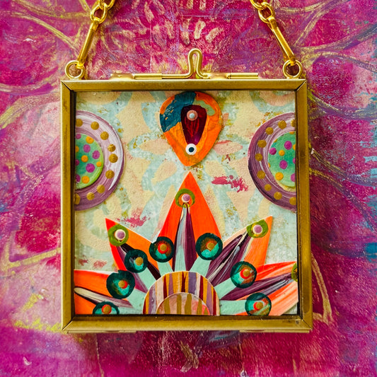 2.5" x 2.5" mixed-media collage is framed between glass in a petite brass hanging frame.
