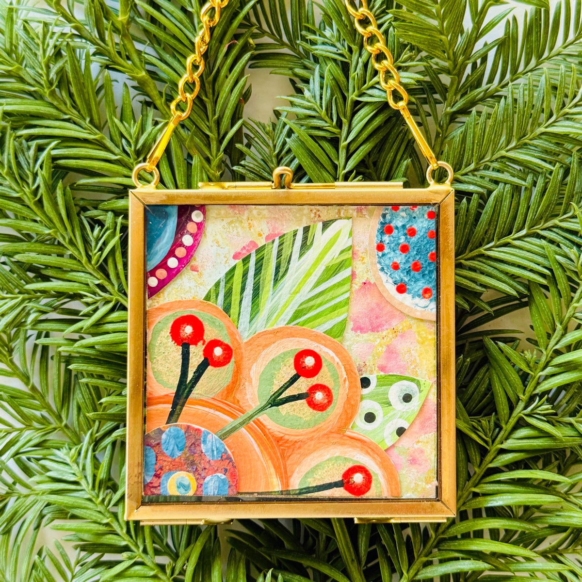 2.5" x 2.5" mixed-media collage is framed between glass in a petite brass hanging frame.