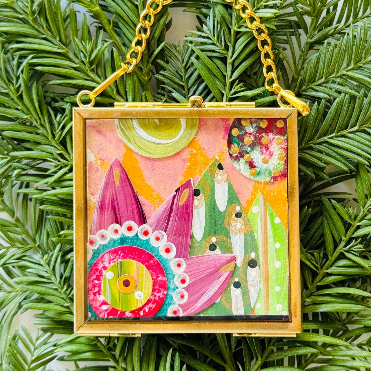 2.5" x 2.5" mixed-media collage is framed between glass in a petite brass hanging frame.