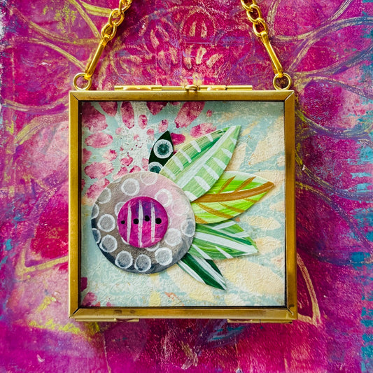 2.5" x 2.5" mixed-media collage is framed between glass in a petite brass hanging frame.