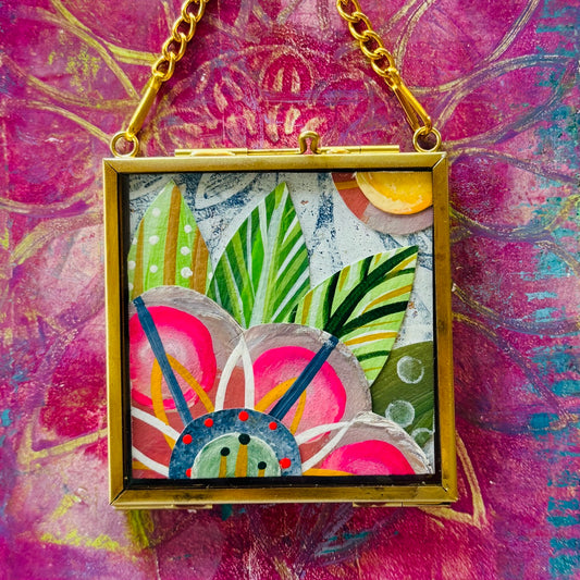 2.5" x 2.5" mixed-media collage is framed between glass in a petite brass hanging frame.