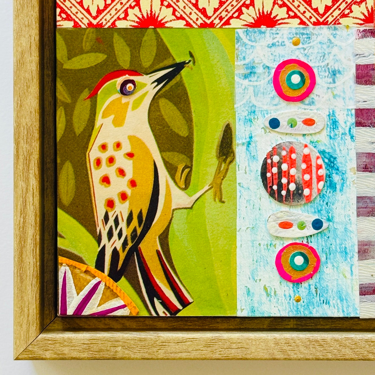 Framed artwork with a colorful bird illustration on the left and abstract circular patterns on the right.