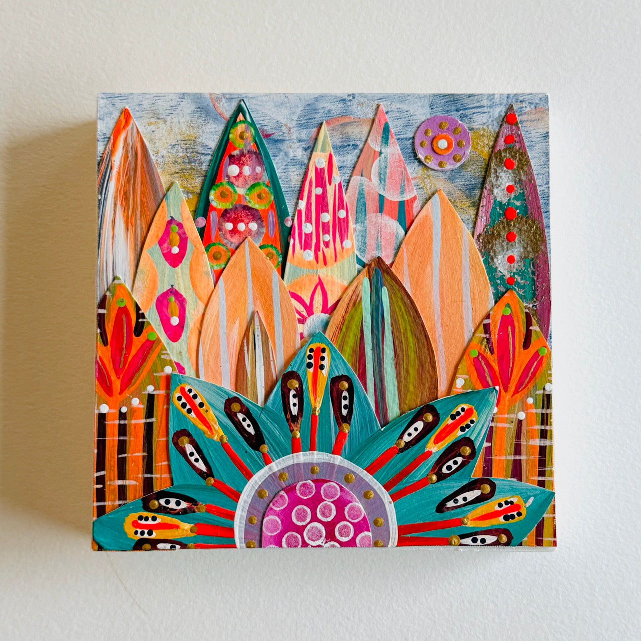 Small square wood panel art with a bold patterned floral design and hand-painted collage elements.