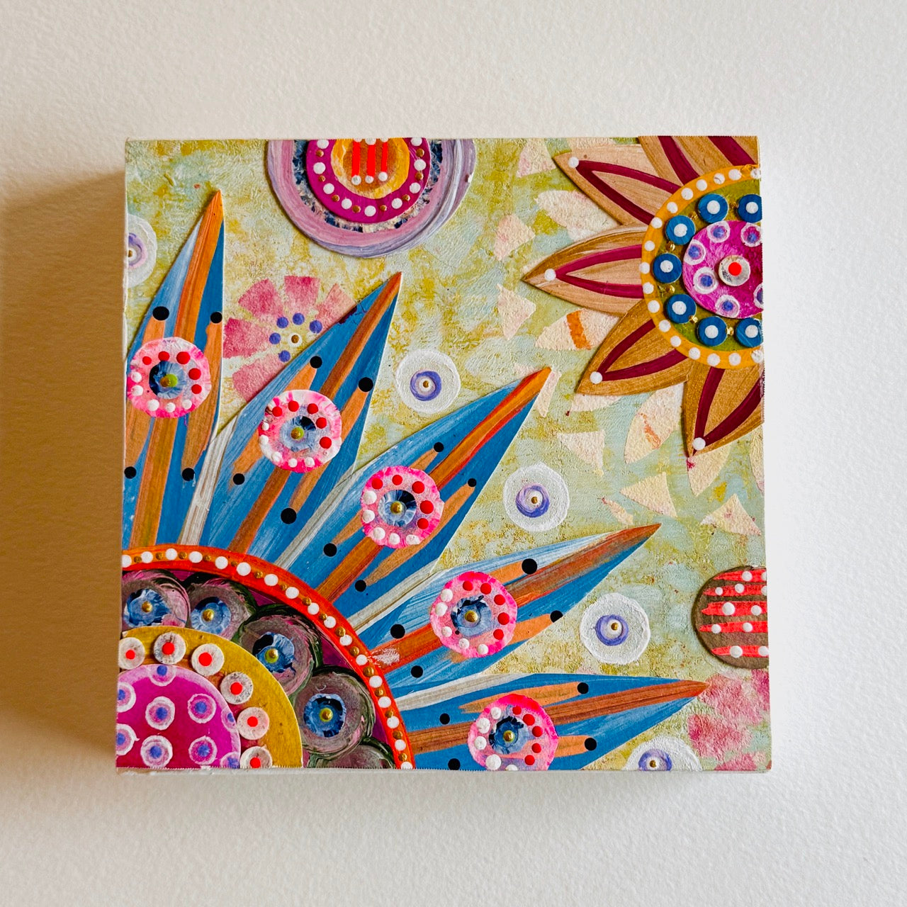 Small square wood panel art with a bold patterned floral design and hand-painted collage elements.