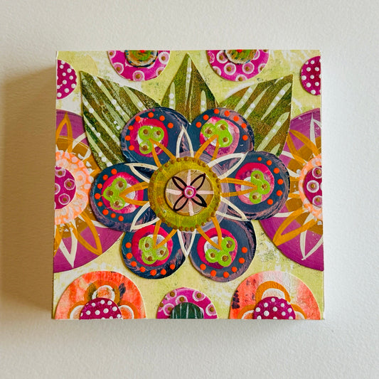 Small square wood panel art with a bold patterned floral design and hand-painted collage elements.
