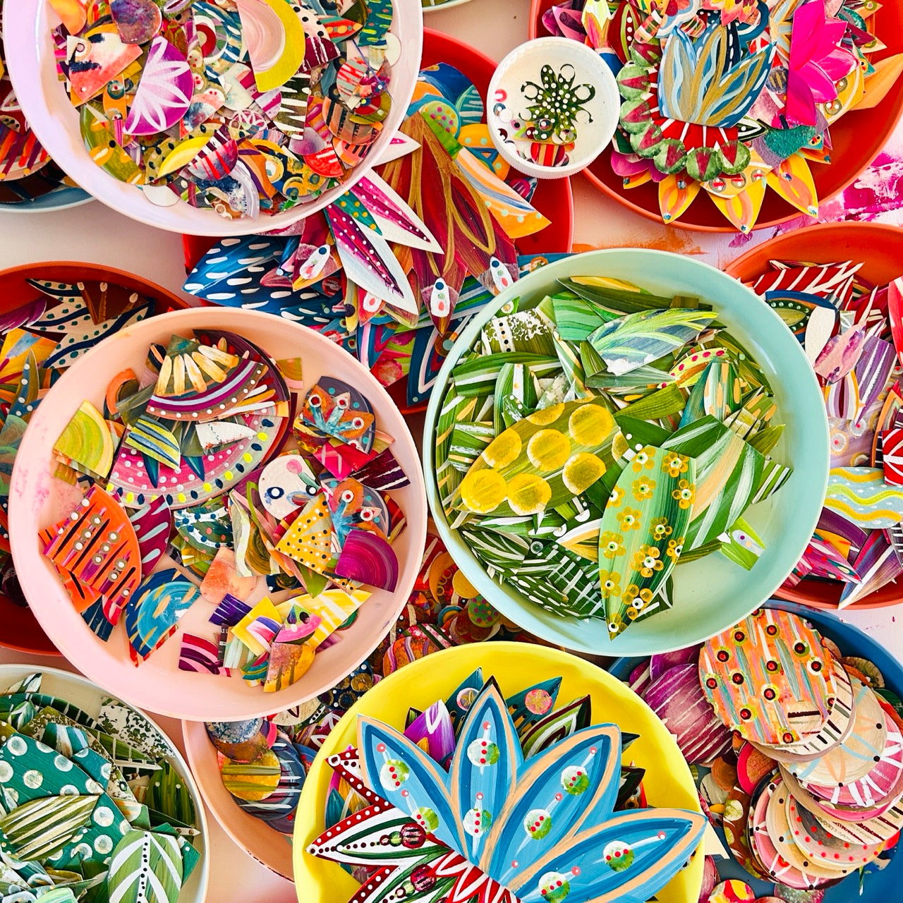 Collection of colorful ceramic plates with various designs on a table.